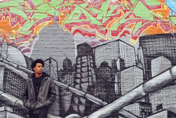 him in front of grafitti